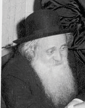 alt="צילום דיוקן בשחור-לבן של הרב ישכר תמר, מחבר סדרת הספרים 'עלי תמר' על התלמוד הירושלמי. הרב נראה במבט הצידה, בעל זקן לבן ארוך, לובש בגדים כהים וחובש לראשו מגבעת שחורה."